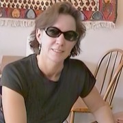 Woman with short brown hair, wearing sunglasses